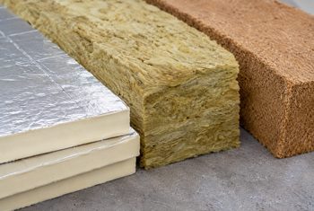 Dakisolatiematerialen vergelijken – PIR, minerale wol en houtvezel Verschillende dakisolatiematerialen naast elkaar: PIR-isolatieplaten, minerale wol en houtvezelisolatie
